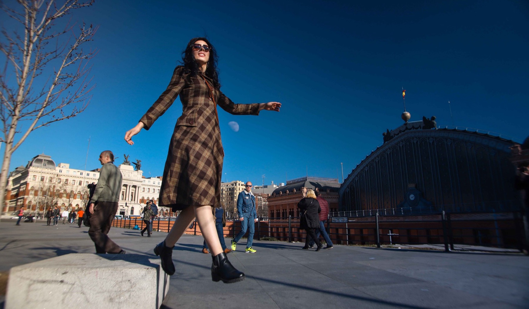 Una mujer camina frente a la estación de Atocha, en Madrid, en un rodaje de calle